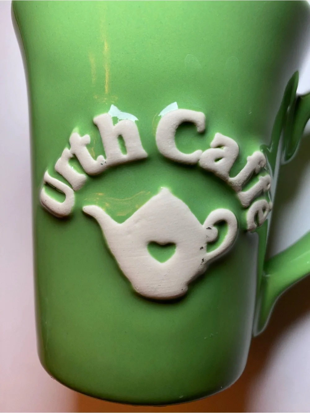 Urth Cafe ceramic coffee mug in green with white embossed logo